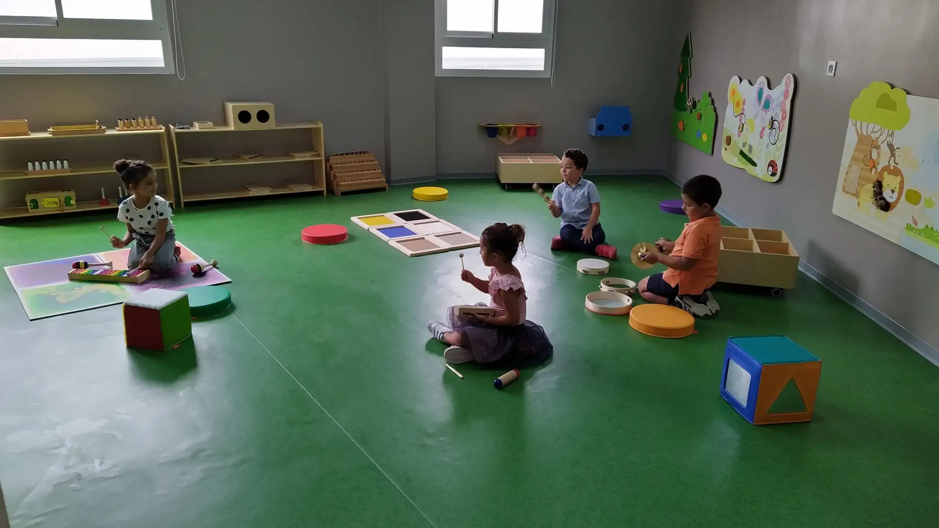 Salle d’activités de la crèche Rainbow Childcare à Bouskoura avec des enfants jouant de la musique
